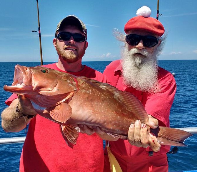 Left-Right- Captain Joe Drew and Santa Clause showing off a beautiful red grouper caught on the 10 hour all day at Hubbard's Marina