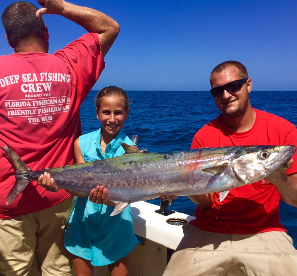 Left-Right- Paul Early, Mia Rosace from st. pete, and Captain Anthony Belmonte showing off a big kingfish from the HUB private charter at Hubbard's Marina